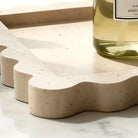 Close-up of the wavy scalloped edge carved in natural travertine