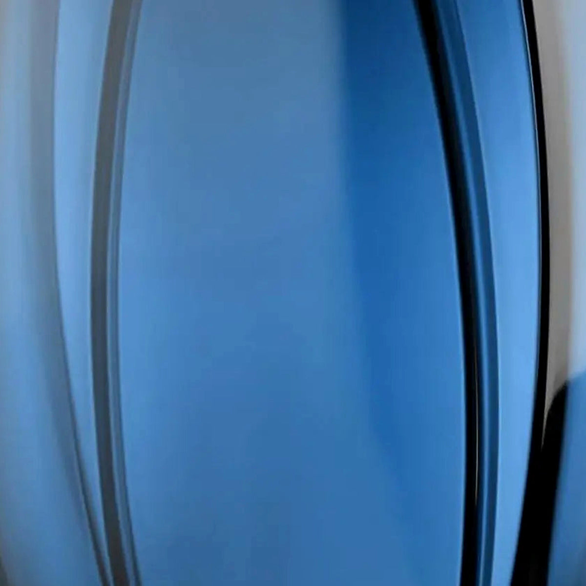 Close-up of the vertical ribbing and deep blue-teal translucence of the art glass vase