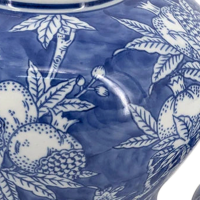 Close-up of the hand-painted cobalt pomegranate and leaf motif on glazed white porcelain