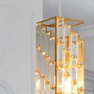 Close-up of staggered clear glass prisms clipped into an open gold rectangular frame