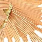 Close-up of a blush iron ginkgo leaf with finely ribbed metalwork and a gilded edge