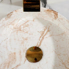 Close-up of the soft gold-and-taupe marble veining inside the glazed ceramic vessel bowl