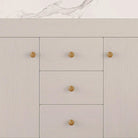 Close-up of the white cabinet doors, drawers and gold knobs