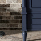 Close-up of a tapered carved French leg and the bottom drawer panel in deep navy