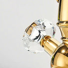 Close-up of a faceted crystal cross handle set in polished gold on the swan-neck faucet