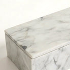 Close-up of the grey Carrara veining and crisp corner of the marble vanity box