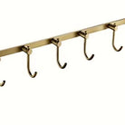 Close-up of the J-hooks and brushed brass bar