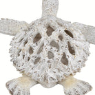 Detail of the openwork coral cutouts across the turtle shell