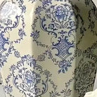 Detail of the intricate blue floral damask motif on the vase's ivory glaze