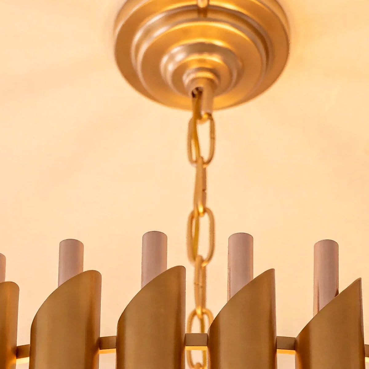Detail of the vertical gold plates crowning the five-tier crystal chandelier