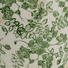 Detail of the embossed green floral trail across the white ceramic body
