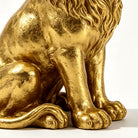 Close-up of the gold lion's seated paws and base