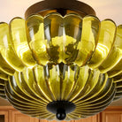 Close-up of warm light through the scalloped green glass shade