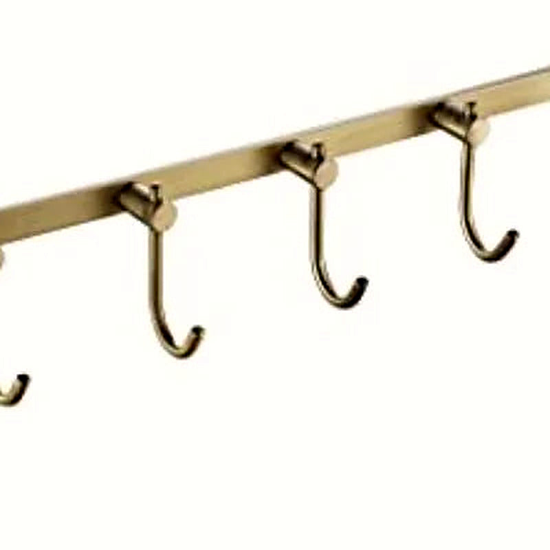 Close-up of individual brushed brass hooks on the rail