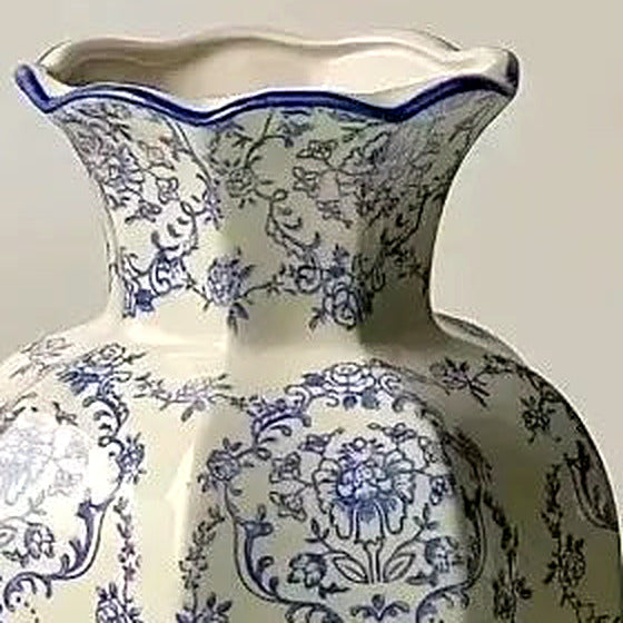 Close-up of the scalloped, blue-edged rim and faceted neck of the porcelain vase