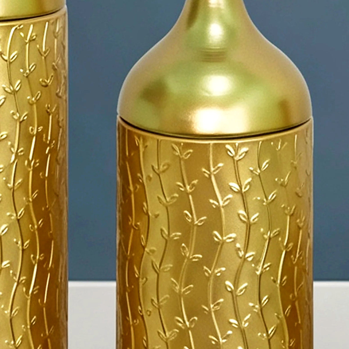 Close-up of the wavy leaf pattern contrasting with the smooth gold neck