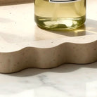 Close-up of the matte travertine surface with natural pits and warm cream tones