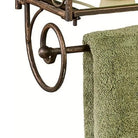 Detail of the antique bronze towel bar with gold highlights beneath the lowest glass shelf