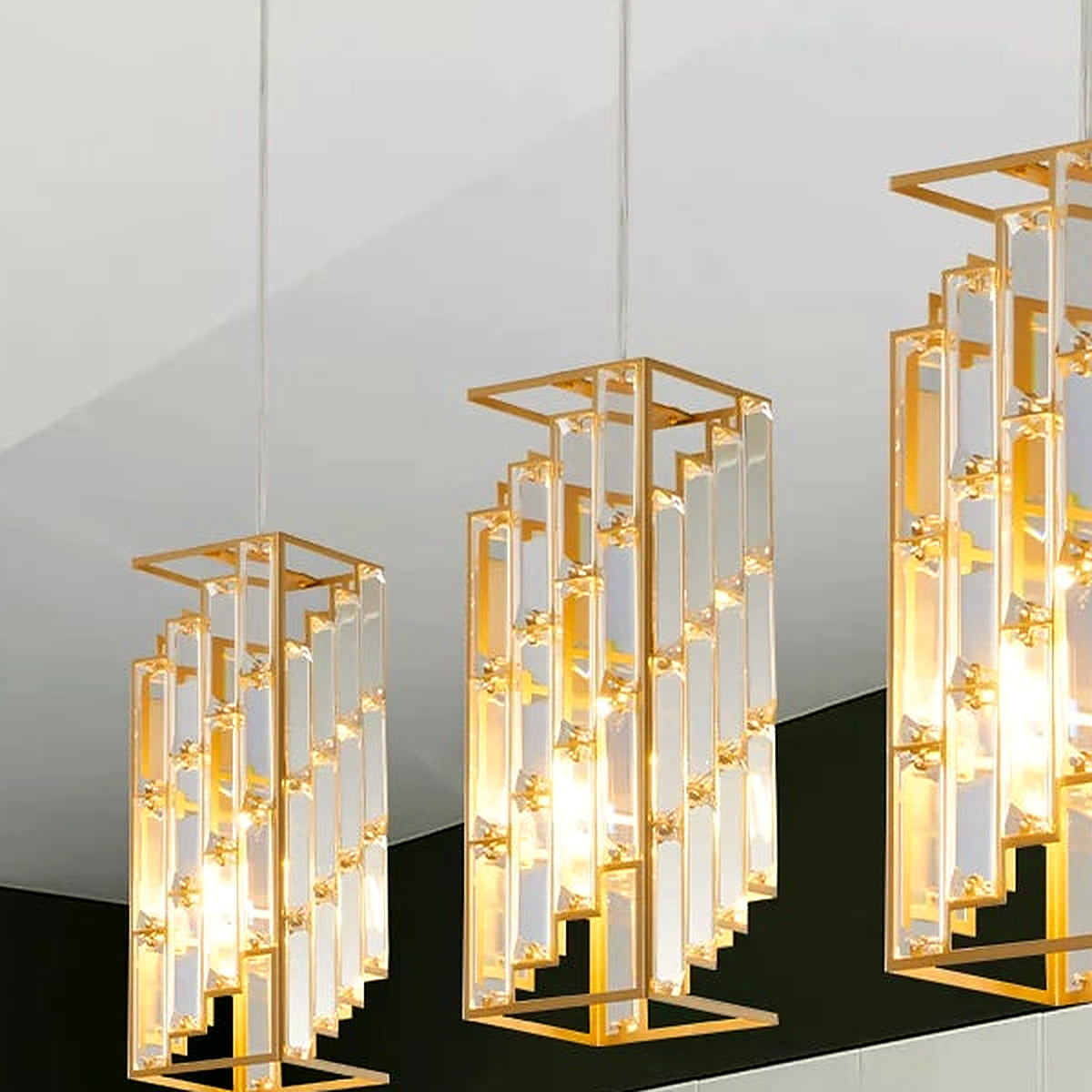 The full set of three gold crystal prism pendants hanging at staggered heights (bulbs shown for illustration)