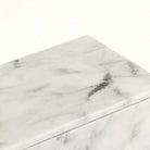 Close-up of the front face of the Carrara white marble box showing dense grey marbling