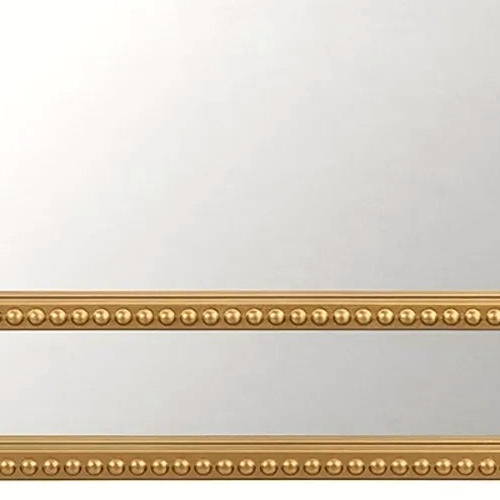 Close-up of the beaded gold bottom rail of the arched mirror