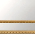 Close-up of the beaded gold bottom rail of the arched mirror