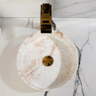 White marble-look ceramic vessel sink, 14 in, with polished gold faucet and drain on a matching marble vanity