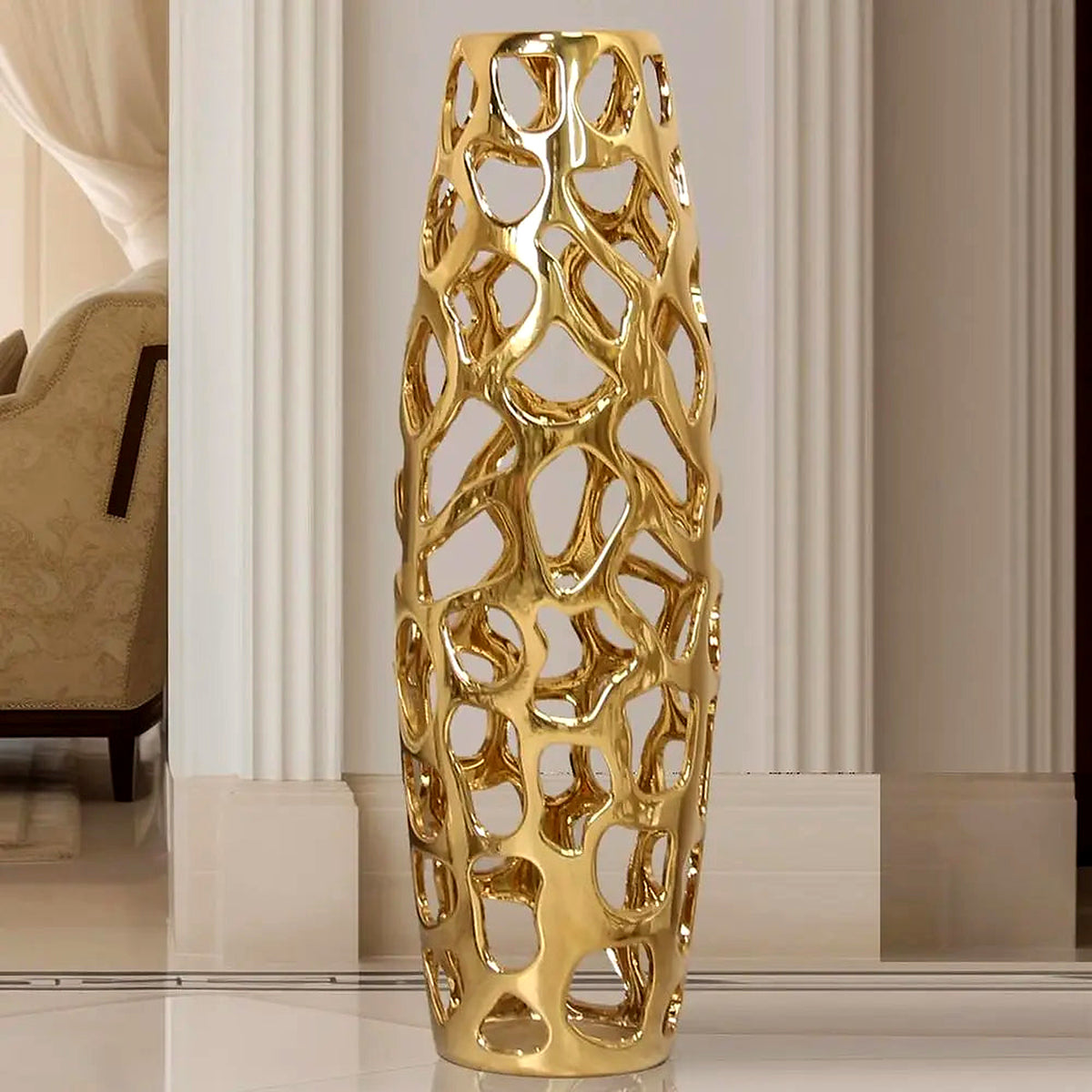Gold openwork ceramic floor vase, 24 in, gleaming in a white entry with classical columns