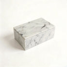 Carrara white marble lidded vanity box with soft grey veining on a clean white backdrop