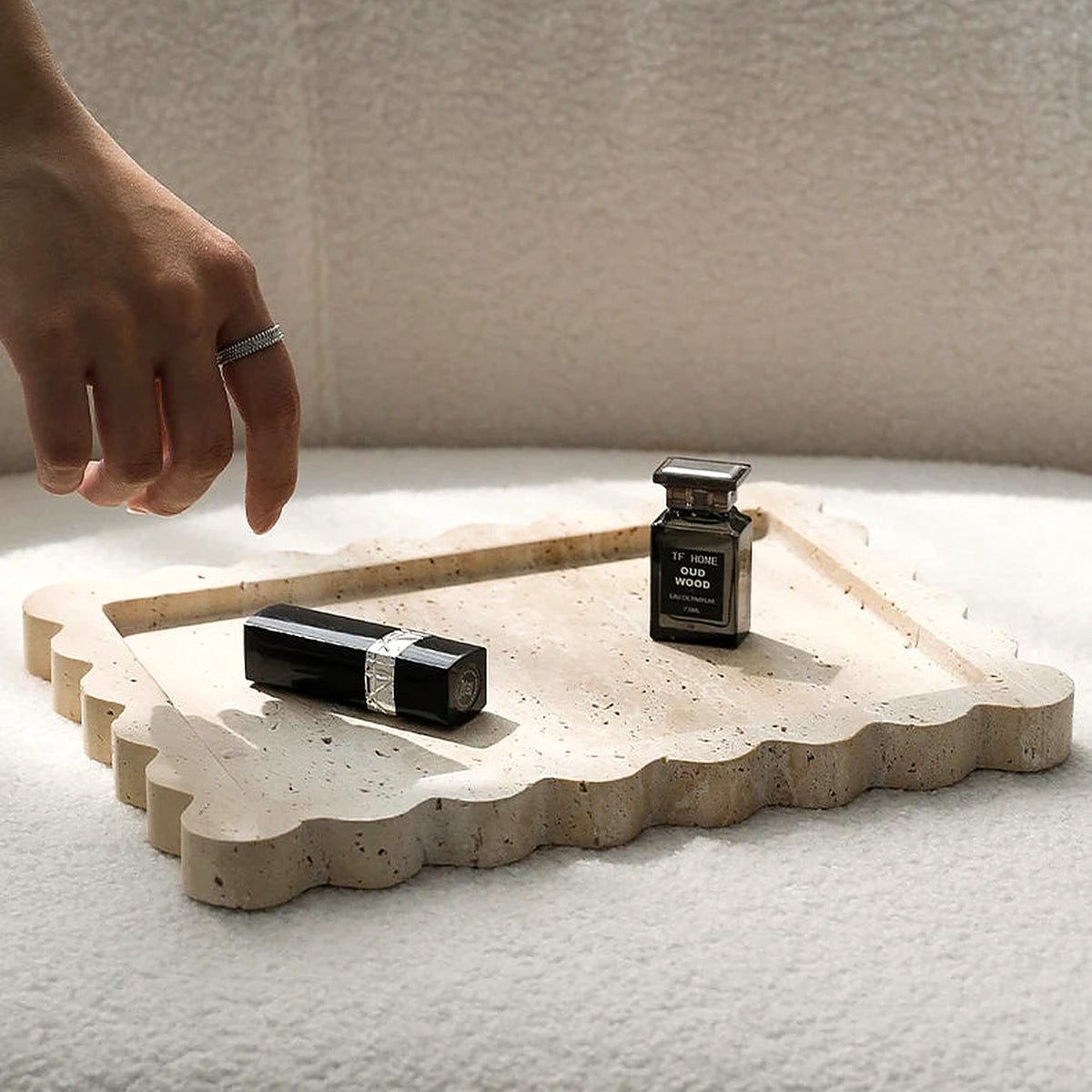Scalloped travertine tray styled with lipstick and perfume (cosmetics shown for styling)