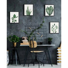 Tropical leaf framed canvas set of four arranged on a dark office wall (desk and décor shown for styling)