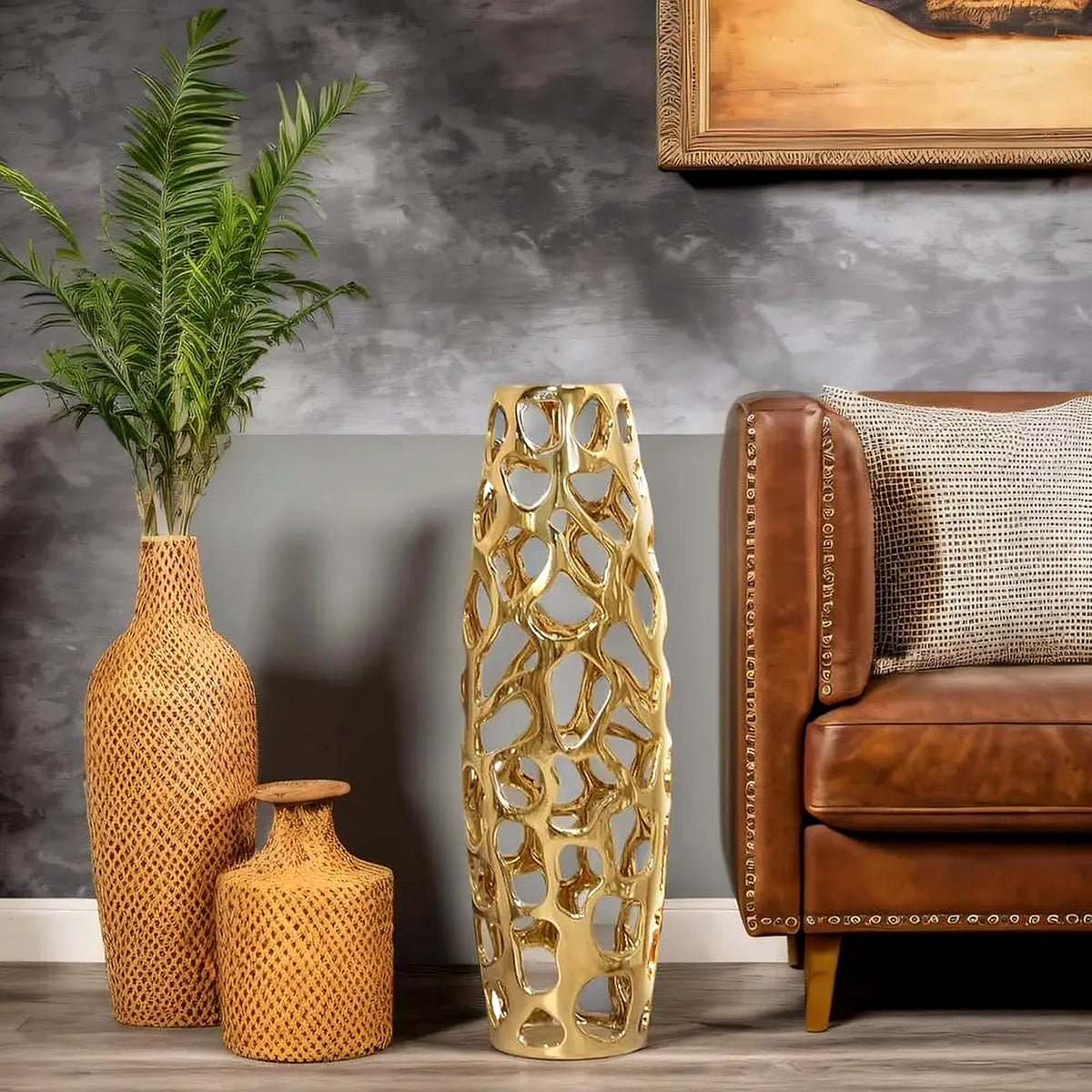 Gold coral-lattice ceramic floor vase beside a cognac leather sofa and woven accent vases