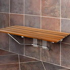 Teak fold-down shower bench mounted on stone tile (tile shown for styling)