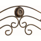 Close-up of the antique bronze scrollwork crest and floral medallion with gold highlights