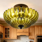 Olive-green petal glass semi-flush light glowing in a kitchen (cabinetry shown for styling)