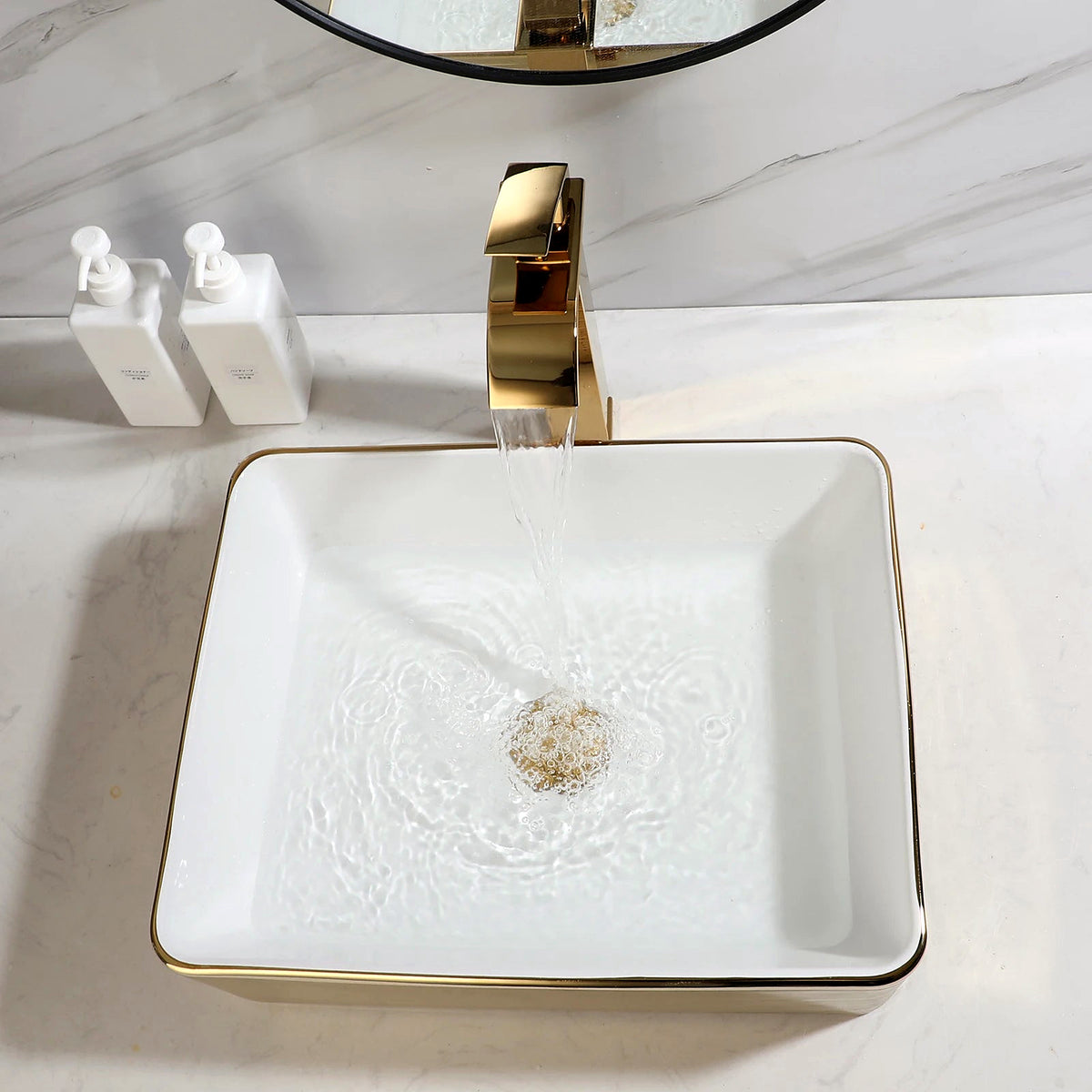 Overhead view of the gold-stripe ceramic vessel sink with water running from the gold faucet