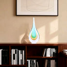 Hand-blown glass teardrop sculpture on a bookshelf (books and décor shown for styling)