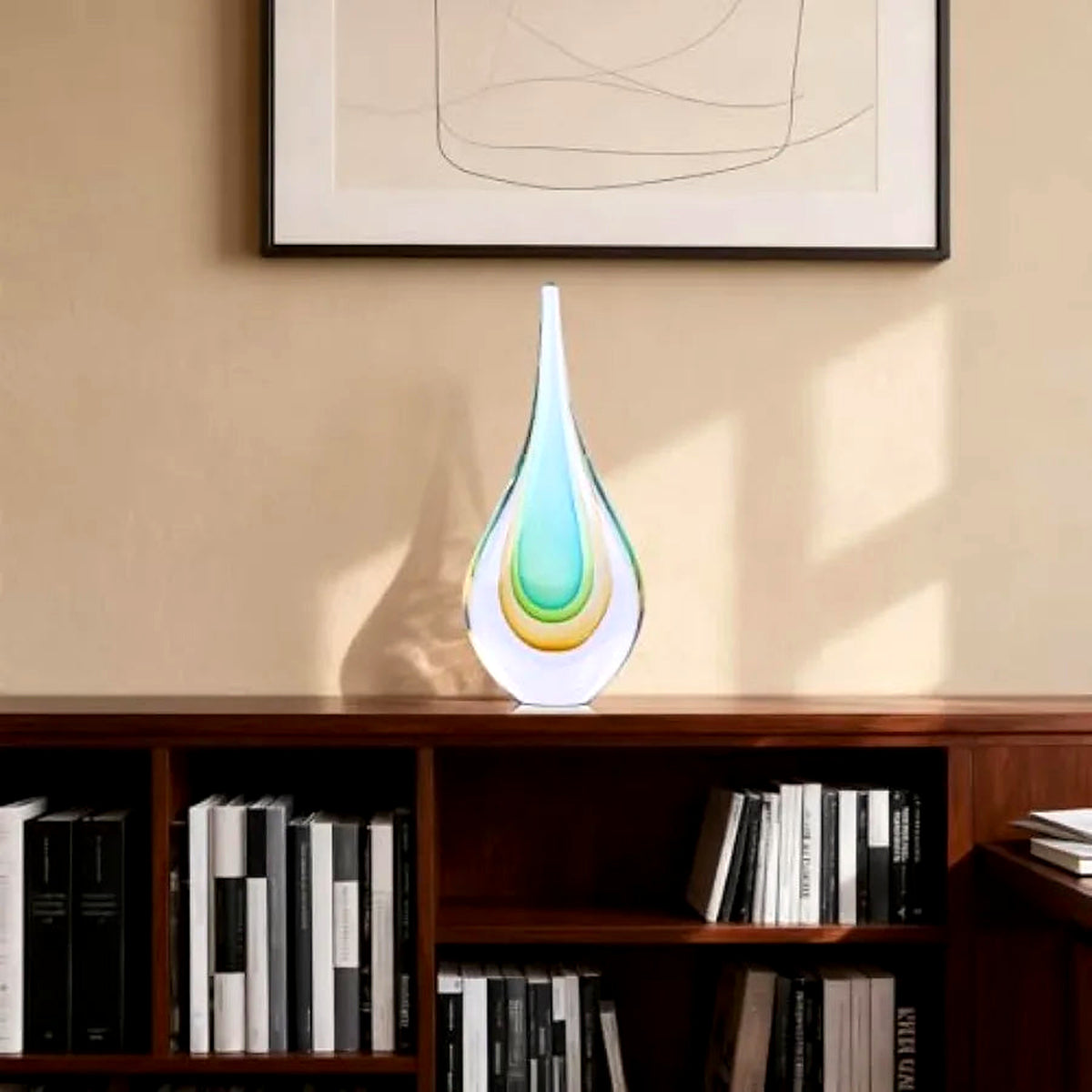 Hand-blown glass teardrop sculpture on a bookshelf (books and décor shown for styling)