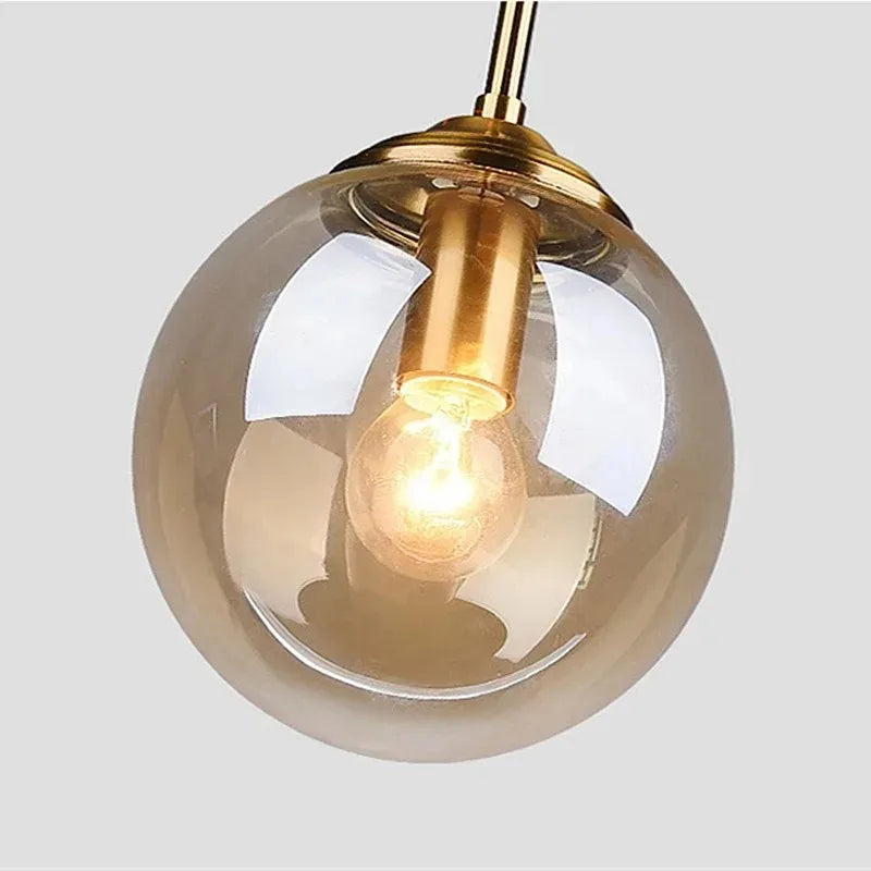 Close-up of an amber glass globe pendant with brass fitting
