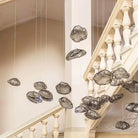 Cluster of smoky grey cloud glass pendants suspended in a stairwell