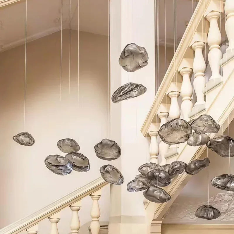 Cluster of smoky grey cloud glass pendants suspended in a stairwell