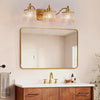 Slow cinematic tour of the gold three-light vanity light with ribbed crystal shades from real product photography